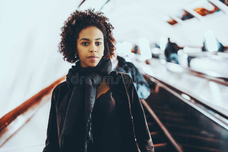 Black cute girl standing on escalator