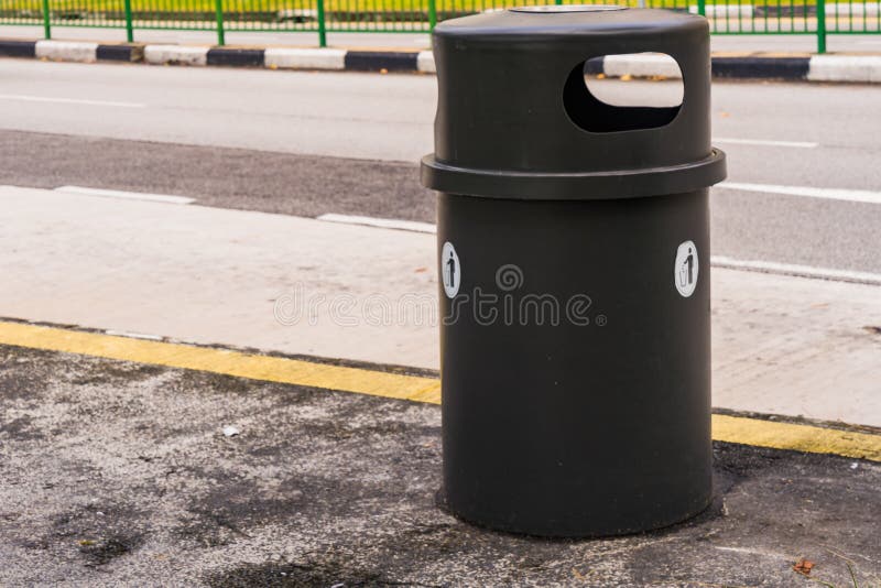 Black dustbin or trashcan beside the road stock photos