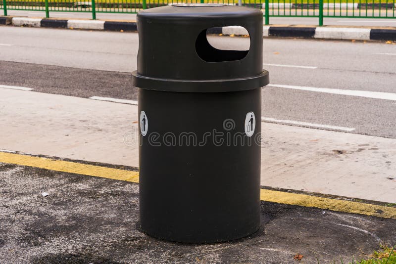 Black dustbin or trashcan beside the road stock photos
