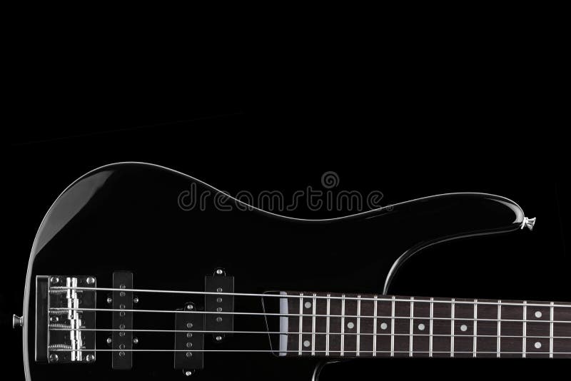 Black Electric Bass Guitar on Black Background with Copy Space Stock