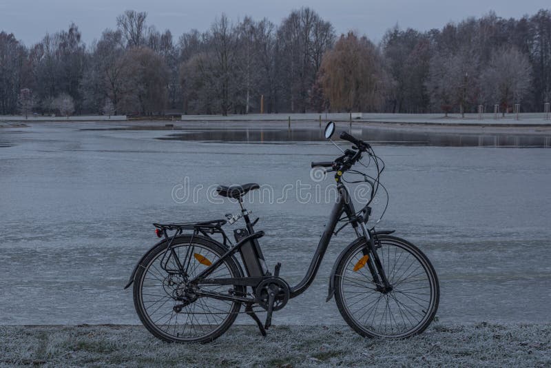 Black electric bicycle near pond in Stromovka garden in Budweis city