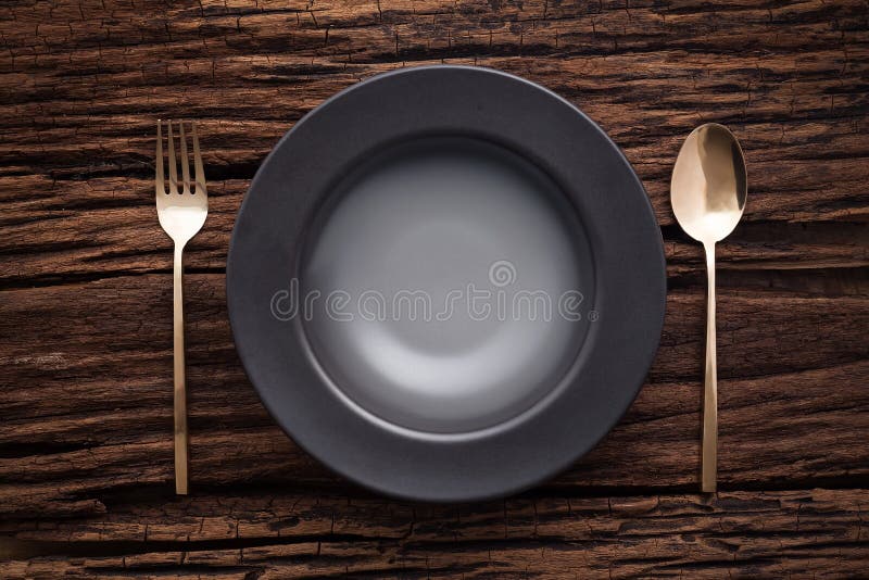 Black empty bowl fork spoon on wooden table background royalty free stock photo
