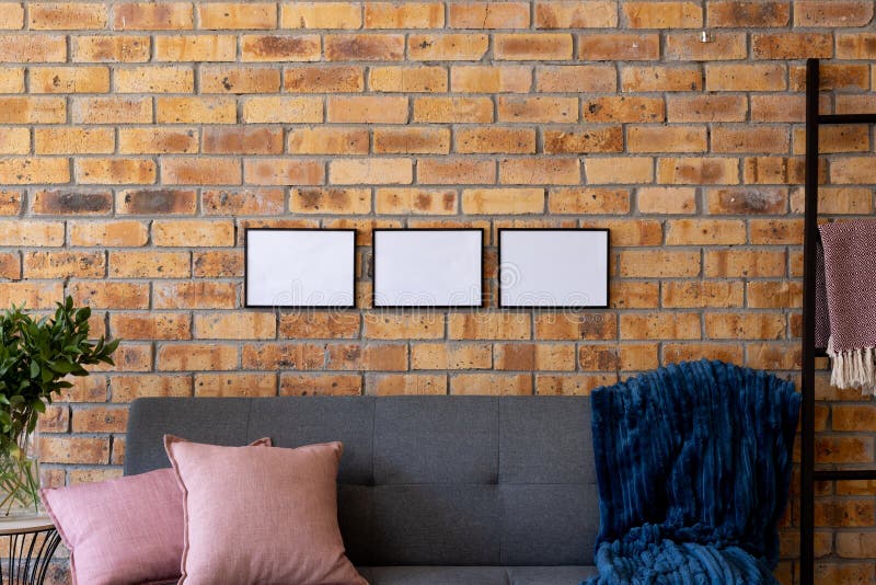 Black Empty Frames with Copy Space and Plant Against Brick Wall in Room