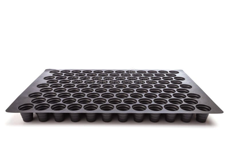 Black empty plastic tray with hole for seedlings isolated on white stock photo