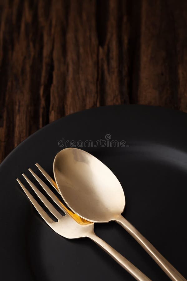 Black empty plate fork spoon on wooden table background royalty free stock photo