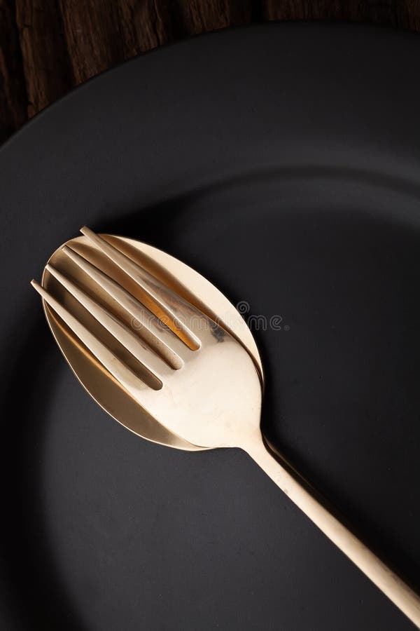 Black empty plate fork spoon on wooden table background stock photography