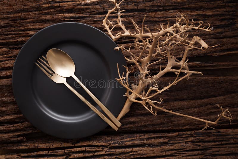 Black empty plate fork spoon on wooden table background stock image