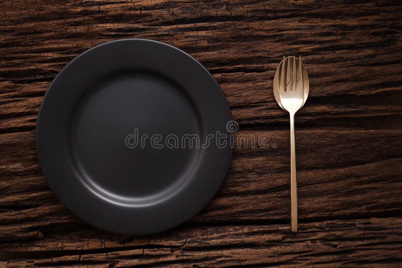 Black empty plate fork spoon on wooden table background royalty free stock photos