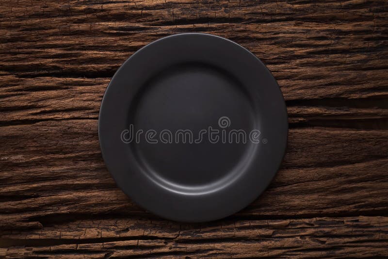 Black empty plate on wooden table background stock photo