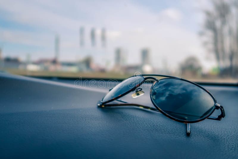 Black Eyeglasses on Black Textured Car Dashboard in Selective Focus