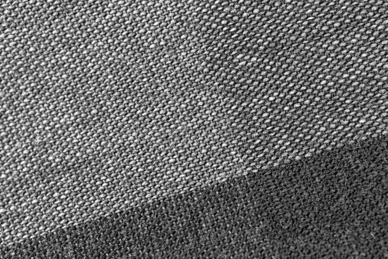 Close-up texture of natural gray fabric or cloth in black color. Fabric  texture of natural cotton or linen textile material. Gray or black canvas  background. Stock Photo