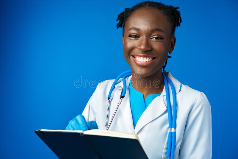 Black Female Doctor Student Wearing a Lab Coat with Book Stock Photo