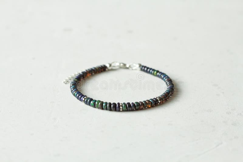 Black Fire Opal Handemade Bracelet Lies on Light Background. Bracelet ...