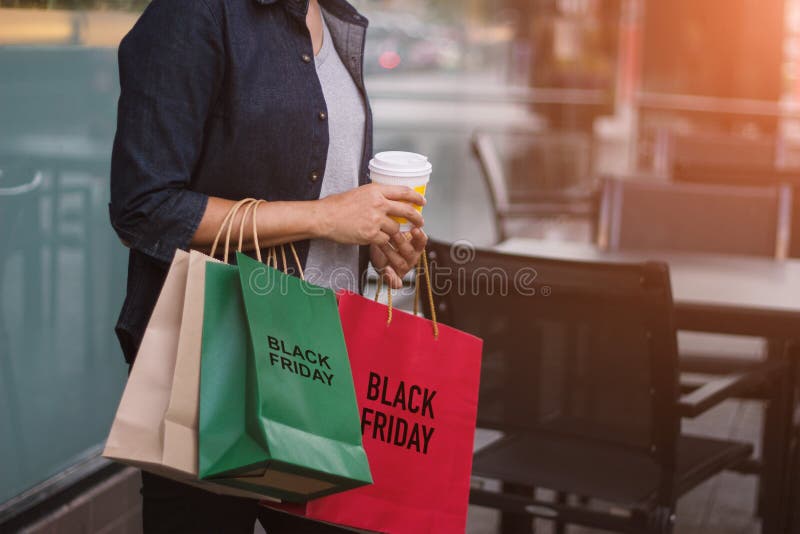 Black Friday, Vrouw met de holding van de koffiekop het winkelen zakken stock fotografie Black Friday, Vrouw met de holding van de koffiekop het winkelen zakken stock fotografie