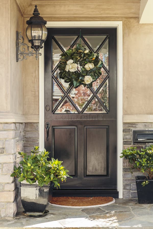 Black front door to home with flower wreath royalty free stock photo Black front door to home with flower wreath royalty free stock photo