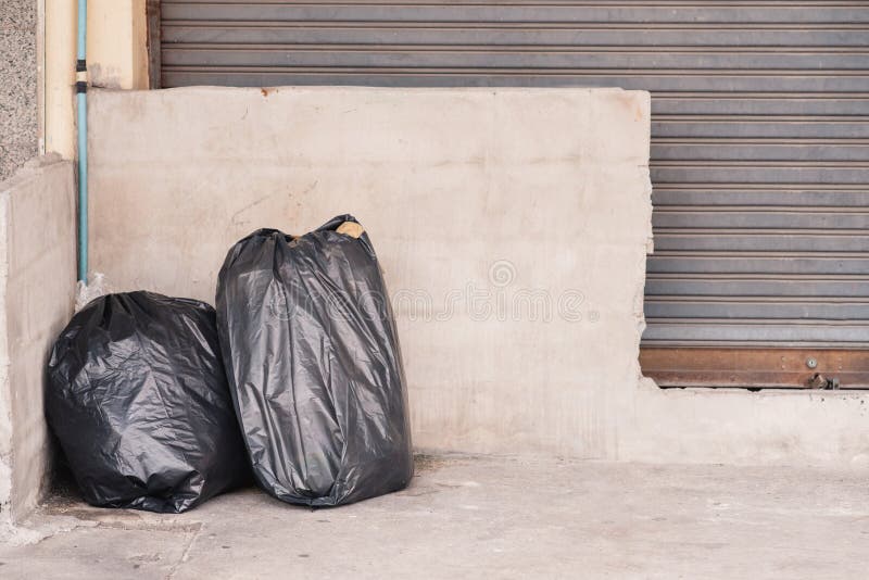 Three big blacks trash bags in front of wall Stock Photo - Alamy