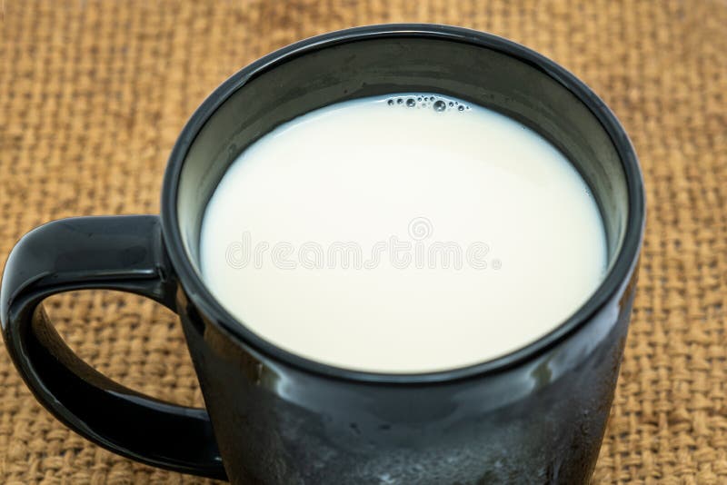 Black Glass of milk on white background. Healthy beverage concept. Top view. Top view, A black Glass of milk on white background. Healthy beverage concept royalty free stock image Black Glass of milk on white background. Healthy beverage concept. Top view. Top view, A black Glass of milk on white background. Healthy beverage concept royalty free stock image