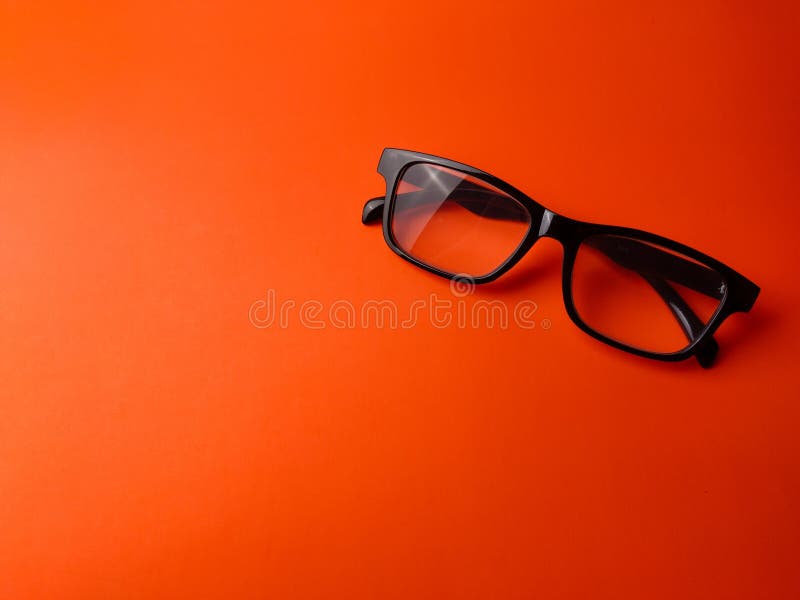 Black glasses on a orange background with copy space royalty free stock images