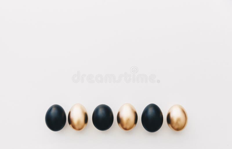 Black and gold eggs. Minimal easter background royalty free stock image
