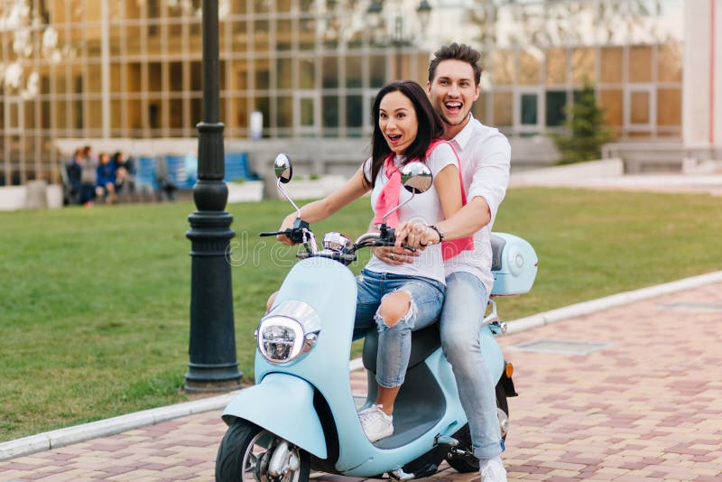 Black-haired Girl with Scared Smile Driving Scooter while Her Boyfriend ...