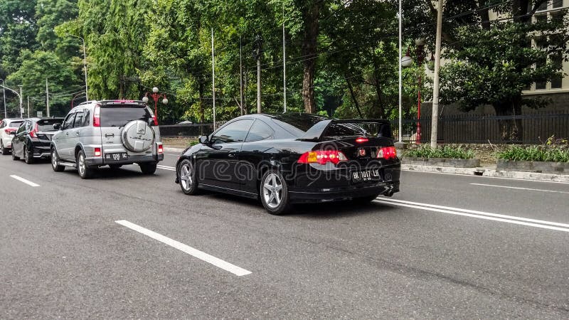 Yogyakarta Indonesia July 27 2021 Black Honda Integra DC5 driving on the road. Honda Integra DC5 or Acura RSX only available in coupe body style and two trim, in asia it available in two trim : Type S the basic trim and Type R as top trim. This car is Type S, powered by K20A3 produced 162 horsepower. Yogyakarta Indonesia July 27 2021 Black Honda Integra DC5 driving on the road. Honda Integra DC5 or Acura RSX only available in coupe body style and two trim, in asia it available in two trim : Type S the basic trim and Type R as top trim. This car is Type S, powered by K20A3 produced 162 horsepower