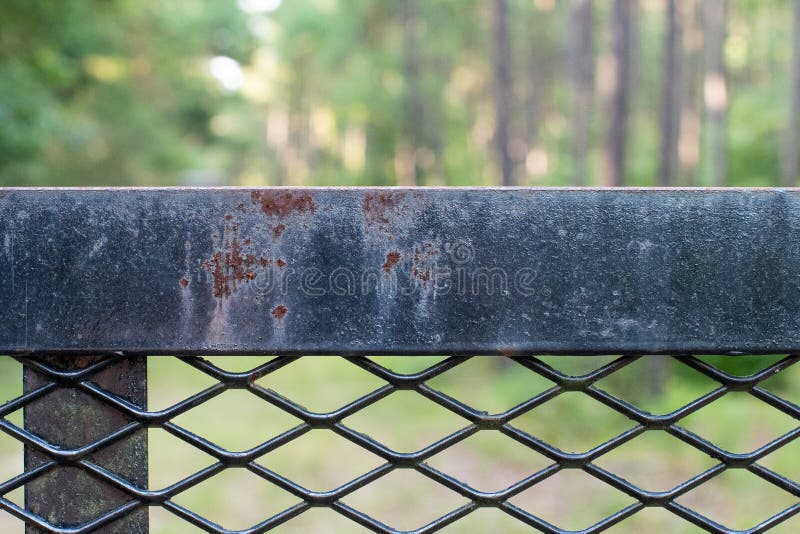 Black Iron Fence with Crisscross Design. ~IRONSIDE~ Black Iron Fence with Crisscross Design and Rusted Texture in the Forest stock photo Black Iron Fence with Crisscross Design. ~IRONSIDE~ Black Iron Fence with Crisscross Design and Rusted Texture in the Forest stock photo