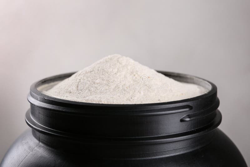 Black Jar Full of Protein Powder on Brown Background Stock Photo