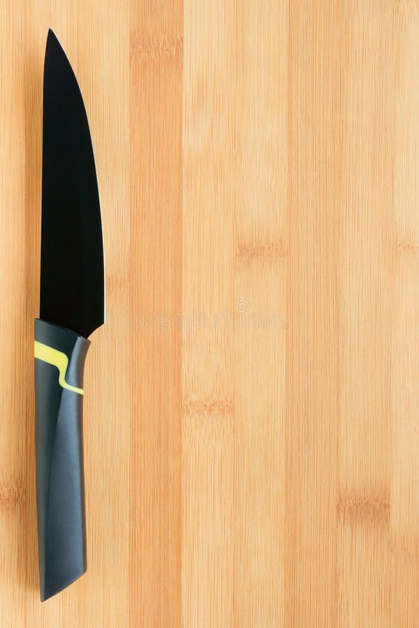 Black kitchen knife on wooden board. Template and background