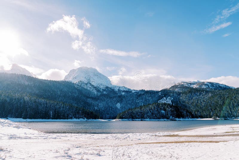 Black lake at the foot of the snowy mountains. Durmitor National Park, Montenegro