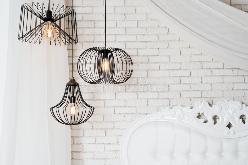 Black Lamps in Light Bedroom Interior. Three Modern Black Lamps Hanging