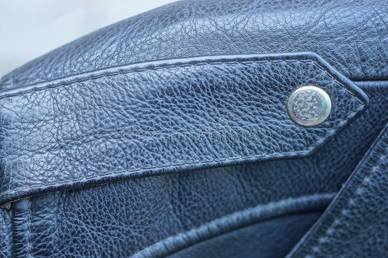 Black leather jacket with a strap and a metal rivet button royalty free stock photo