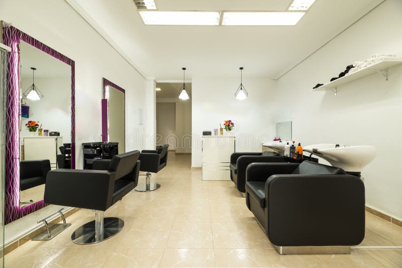 Black Leather Sofas in a Beauty Salon with Rectangular Mirrors on the