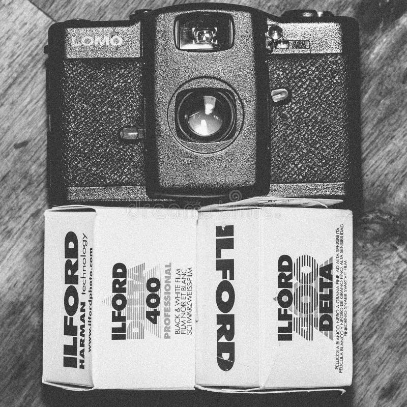 Black Lomo Compact Camera Beside Ilford Delta 400 Black & White Film
