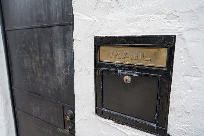 Black mail slot and lock outside of door of building royalty free stock image