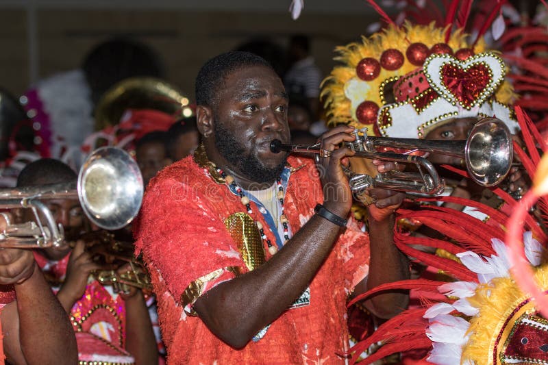 A black man dressed in a white and red costume blowing a trumpet with hearts during the Junkanoo street parade in The Bahamas. A black man dressed in a white and red costume blowing a trumpet with hearts during the Junkanoo street parade in The Bahamas.