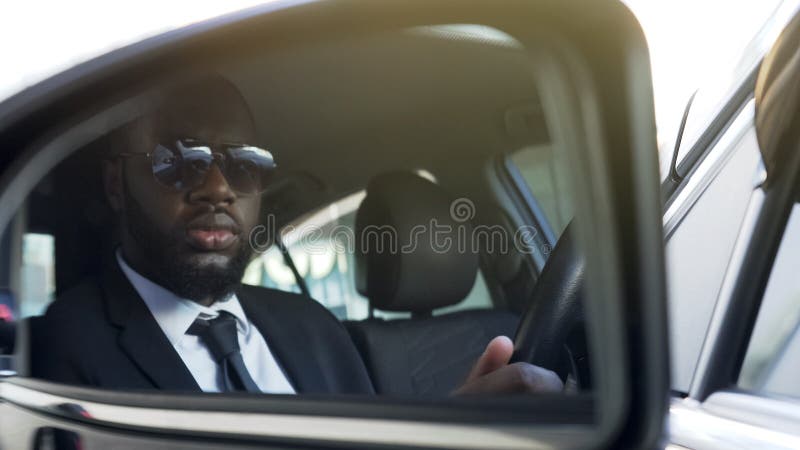 https://thumbs.dreamstime.com/b/black-man-sunglasses-driving-car-looking-side-view-mirror-bodyguard-black-man-sunglasses-driving-car-looking-side-view-126259226.jpg