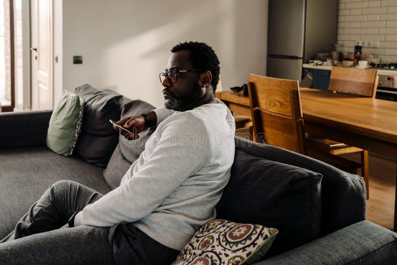 Black Man Wearing Eyeglasses Watching Tv while Resting on Sofa Stock Photo Image of watch