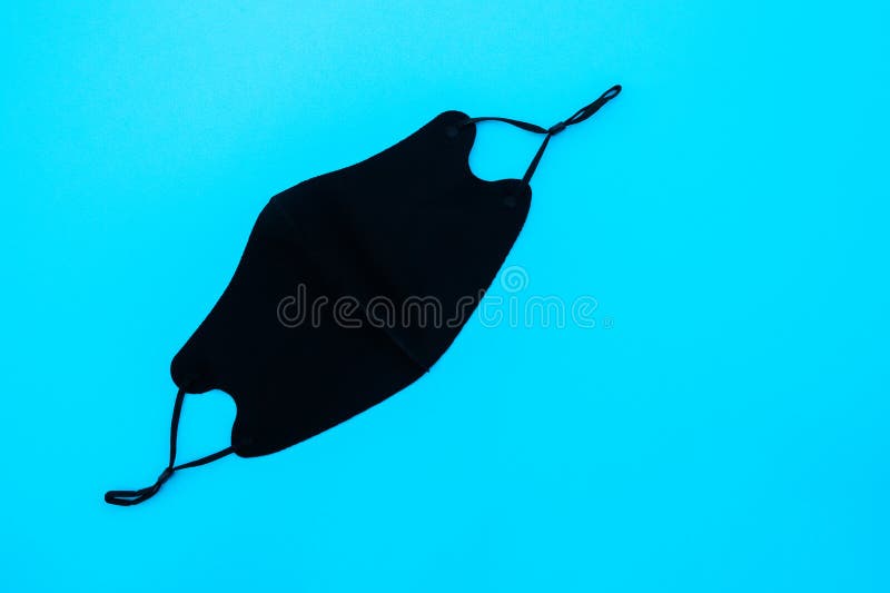 Black Mask on the Blue Background.Black Face Mask during a Virus COVID