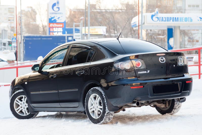 Vista trasera del Mazda 3 negro año 2008 con interior gris oscuro en excelentes condiciones en un espacio de estacionamiento entre otros autos Fotografía editorial - Imagen de familia moderna: 167763712