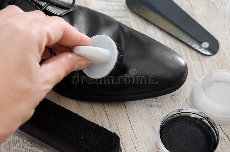 Black men`s shoes with accessories for care. Hand to clean a man’s shoe, close-up. stock image Black men`s shoes with accessories for care. Hand to clean a man’s shoe, close-up. stock image