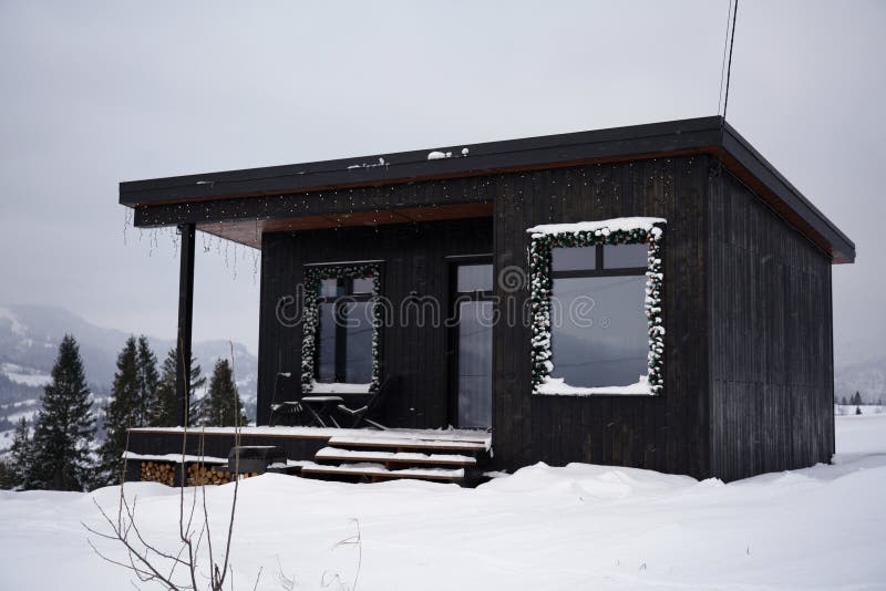 Black Modern Tiny Cabin with Mountain View in Winter Stock Photo