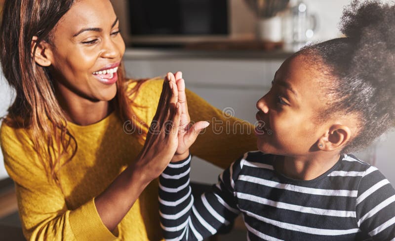 Black mother and child high five stock photography