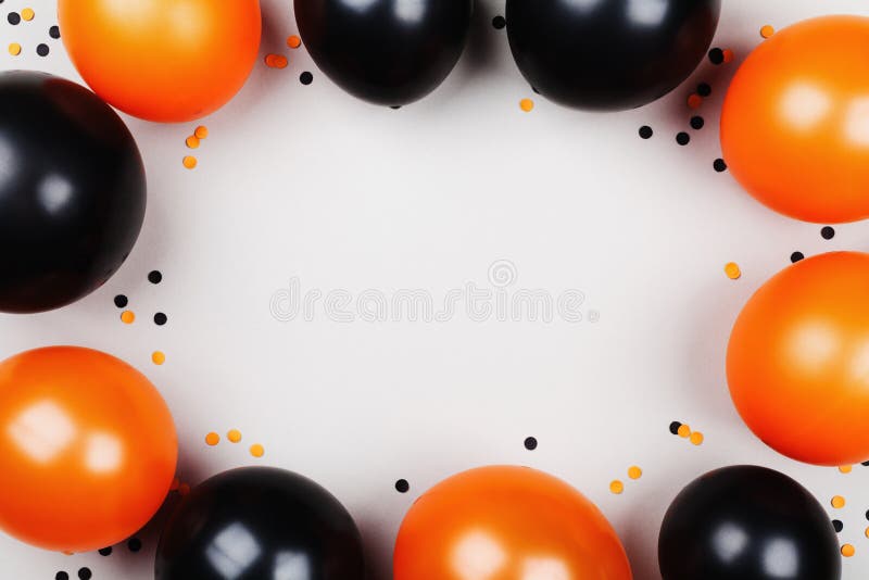 Black and orange balloons and confetti frame for Halloween card or invitation. Flat lay style.