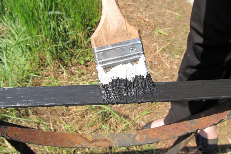 A Black Paint Brush Paints a Rusty Metal Railing on a Sunny Day Stock Photo Image of black
