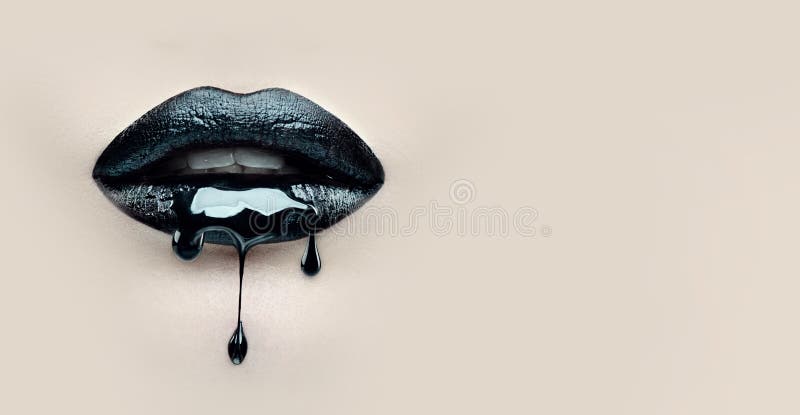 Black Paint dripping from the lips, dark liquid drops on beautiful model girl`s mouth on beige background. Halloween party make-up