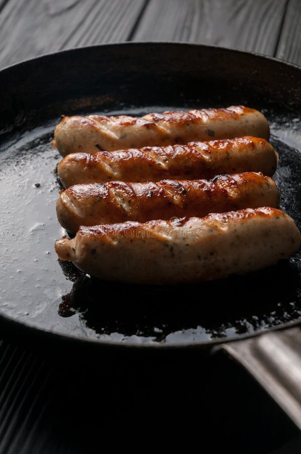 Black Pan with Delicious Sausages on the Grill on the Kitchen Table