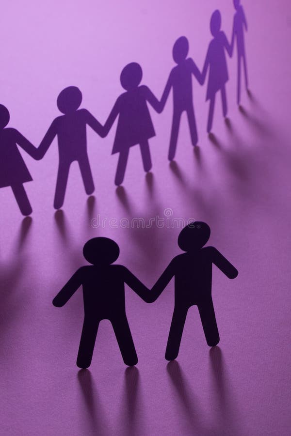 Black paper figure of male couple in front of a crowd of paper people holding hands on purple surface. Social movement