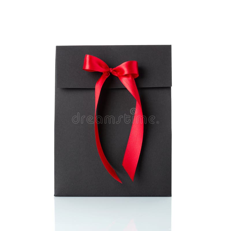 Black paper gift bag with red bow isolated on white background