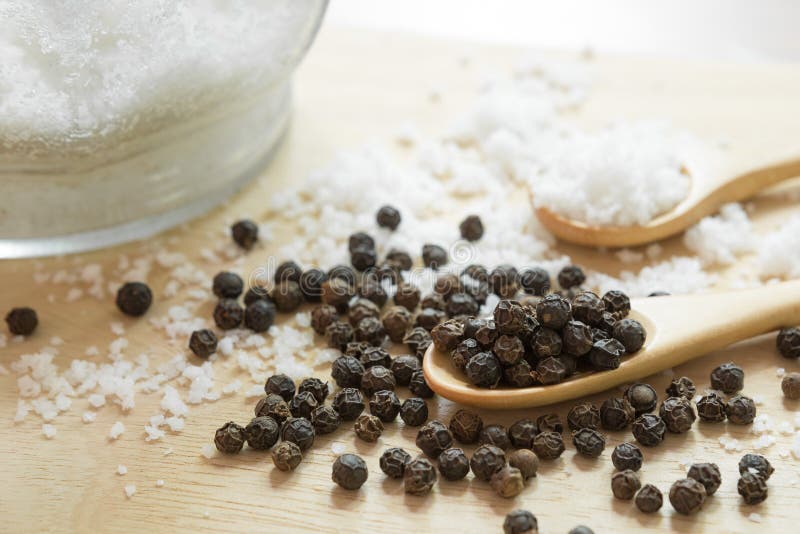 Black Pepper and Salt in Wooden Spoon on the Kitchen Table and Copy