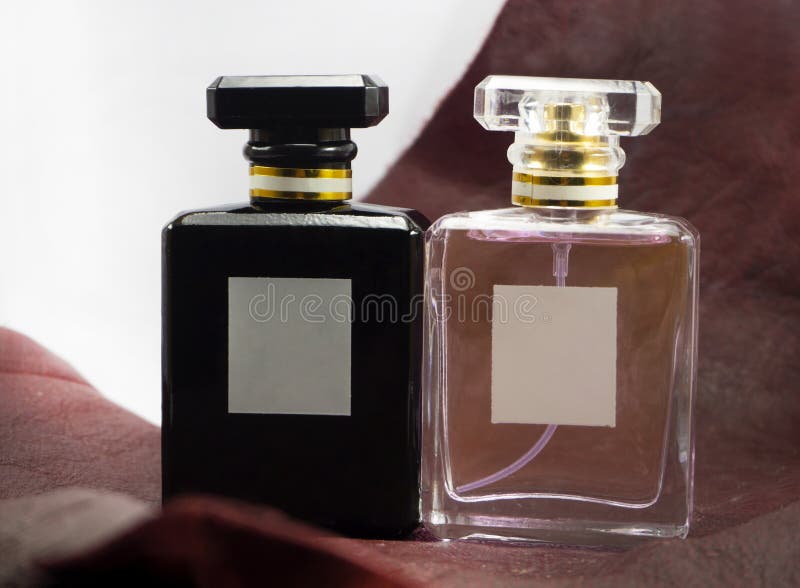 Black and pink perfume bottle On a white background with brown leather.Perfume is made of essential oils with an alcohol solution. stock photo Black and pink perfume bottle On a white background with brown leather.Perfume is made of essential oils with an alcohol solution. stock photo